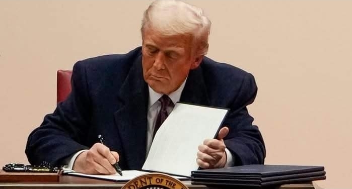 Trump signing an executive order to pause foreign development aid. 